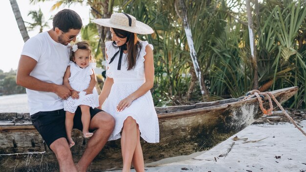 Familia joven con pequeña hija en vacaciones junto al mar