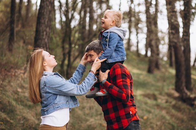 Familia joven con pequeño hijo en el bosque