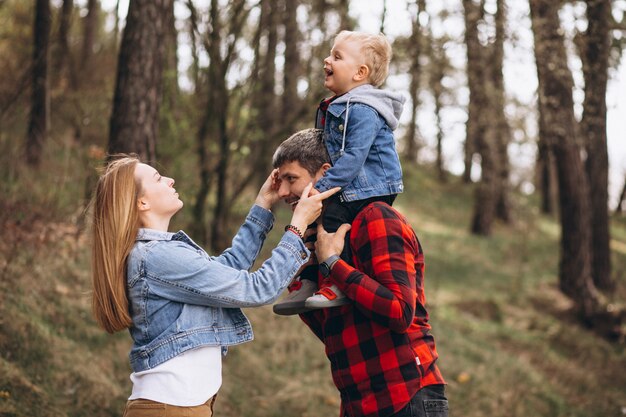 Familia joven con pequeño hijo en el bosque