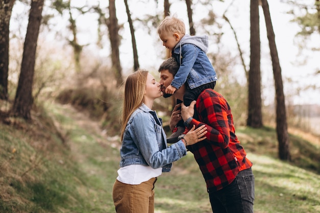 Familia joven con pequeño hijo en el bosque