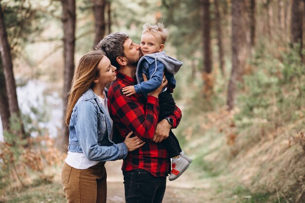 Familia joven con pequeño hijo en el bosque