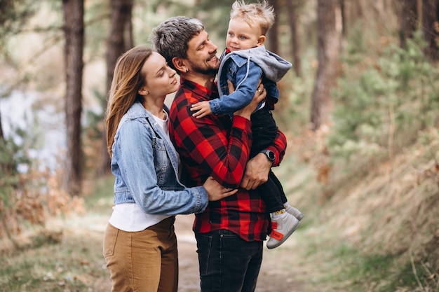 Familia joven con pequeño hijo en el bosque