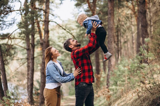 Familia joven con pequeño hijo en el bosque