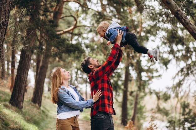 Familia joven con pequeño hijo en el bosque