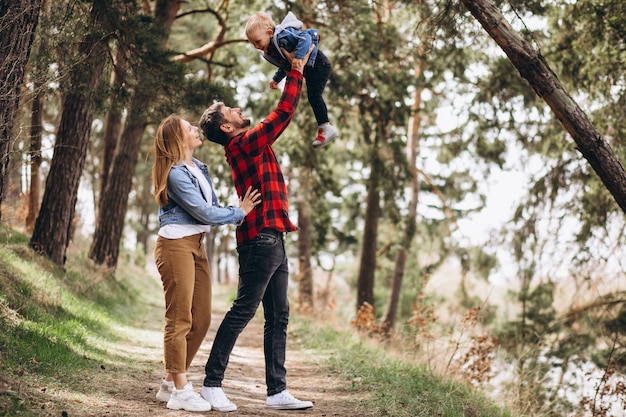 Familia joven con pequeño hijo en el bosque