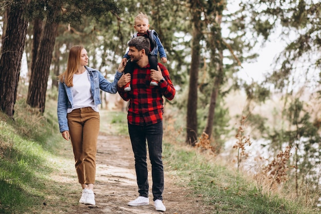 Foto gratuita familia joven con pequeño hijo en el bosque