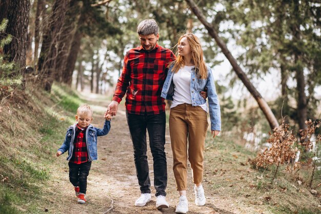 Familia joven con pequeño hijo en el bosque