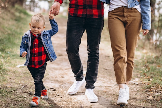 Familia joven con pequeño hijo en el bosque