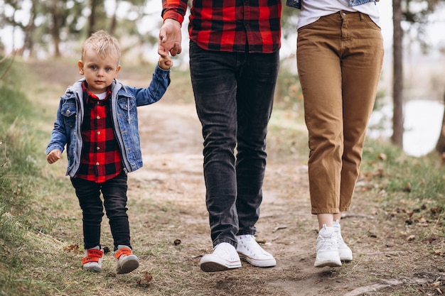 Familia joven con pequeño hijo en el bosque