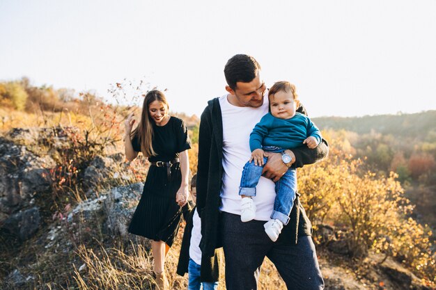 Familia joven con pequeño hijo caminando en el parque