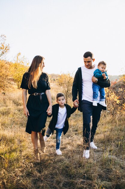 Familia joven con pequeño hijo caminando en el parque