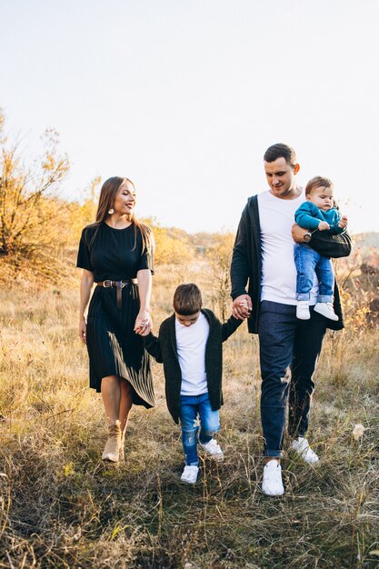 Familia joven con pequeño hijo caminando en el parque