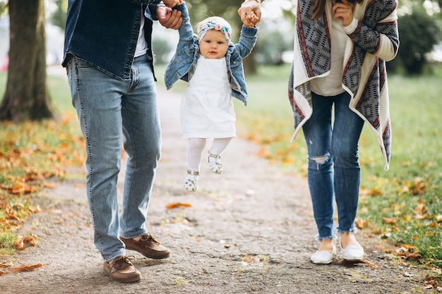 Familia joven con su pequeña hija en el parque otoño