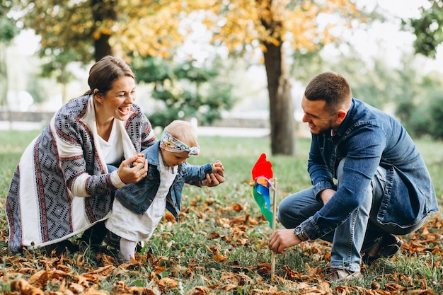 Familia joven con su pequeña hija en el parque otoño