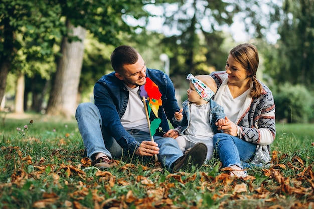 Familia joven con su pequeña hija en el parque otoño