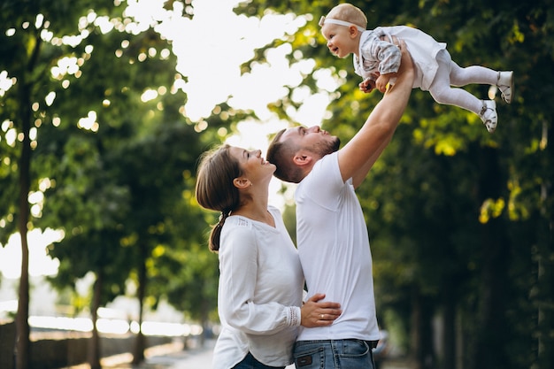 Familia joven con su pequeña hija en el parque otoño