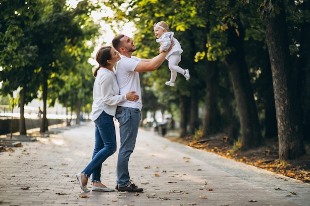 Familia joven con su pequeña hija en el parque otoño