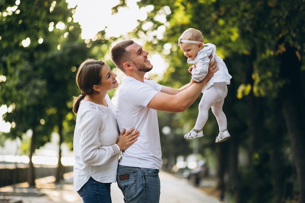 Familia joven con su pequeña hija en el parque otoño