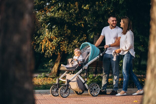 Familia joven con su pequeña hija en el parque otoño