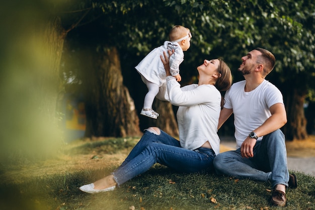 Familia joven con su pequeña hija en el parque otoño