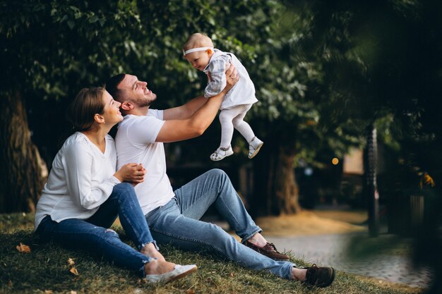 Familia joven con su pequeña hija en el parque otoño