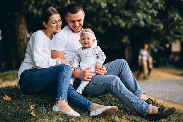 Familia joven con su pequeña hija en el parque otoño