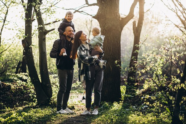 Familia joven con sus hijos divirtiéndose en el bosque