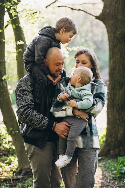 Familia joven con sus hijos divirtiéndose en el bosque