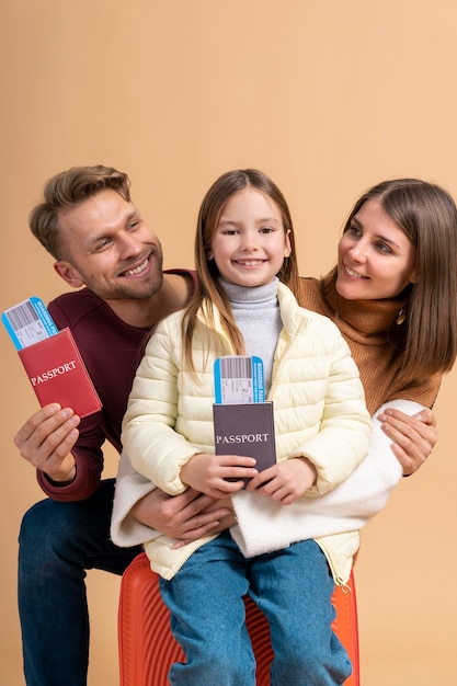 Familia joven de tres posando juntos antes de viajar de vacaciones