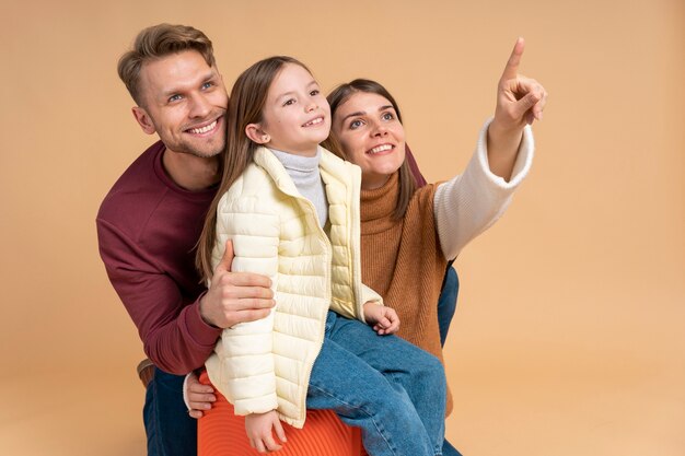 Familia joven de tres posando juntos antes de viajar de vacaciones