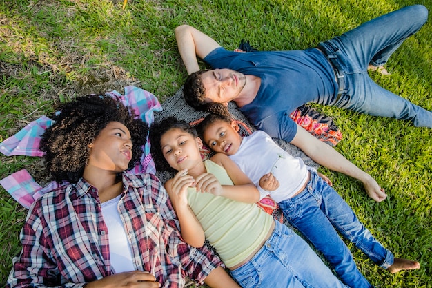 Familia joven tumbada en el césped