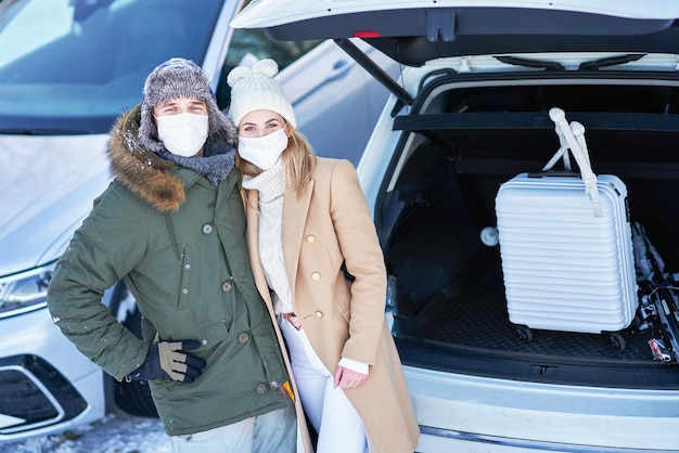 Familia joven durante el viaje de invierno en el maletero del coche en fundamento. foto de alta calidad