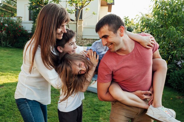 Familia juguetona divirtiéndose juntos en el parque