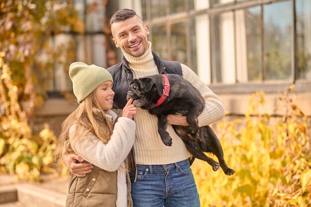 Familia junta. Un hombre y su hija caminan con su perro.