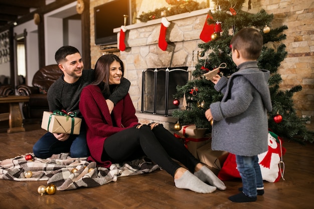 Familia junto a la chimenea en Navidad