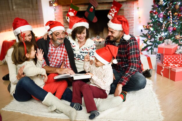 Familia leyendo un libro juntos en su sala de estar