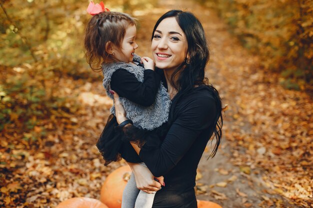 Familia linda y elegante en un parque de otoño