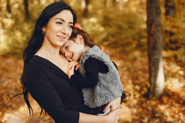 Familia linda y elegante en un parque de otoño