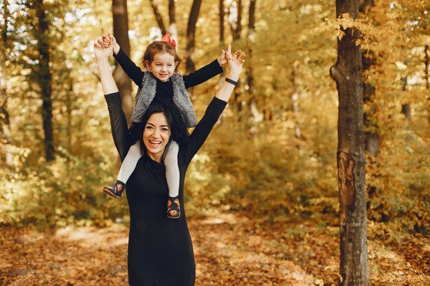 Familia linda y elegante en un parque de otoño