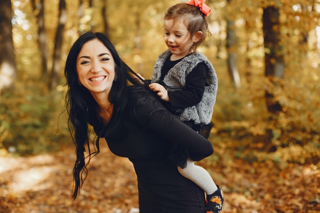 Familia linda y elegante en un parque de otoño