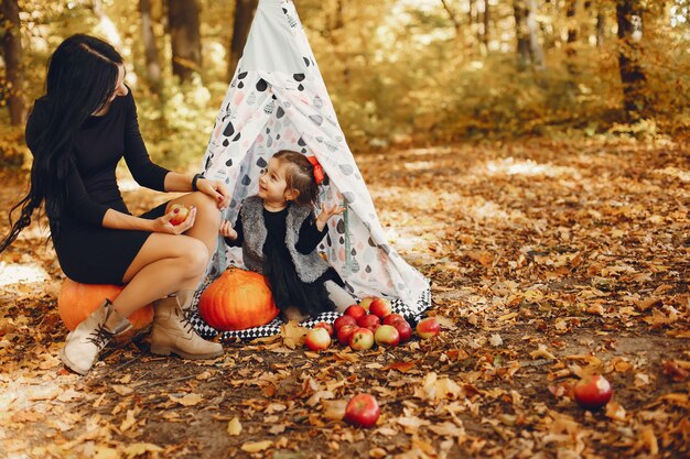 Familia linda y elegante en un parque de otoño