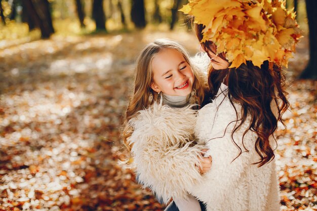 Familia linda y elegante en un parque de otoño