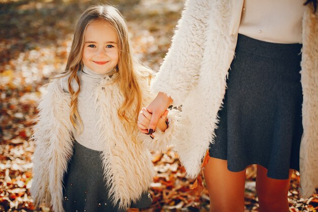 Familia linda y elegante en un parque de otoño