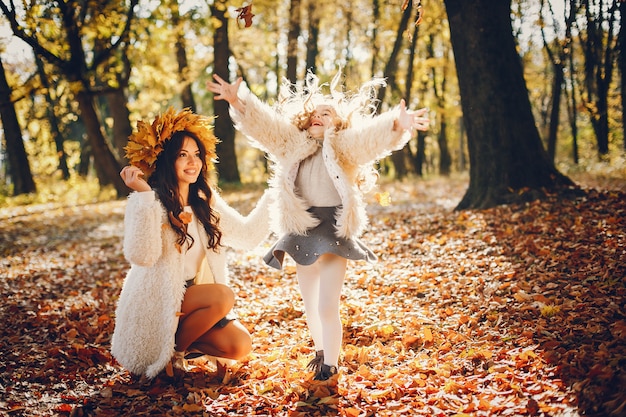 Familia linda y elegante en un parque de otoño