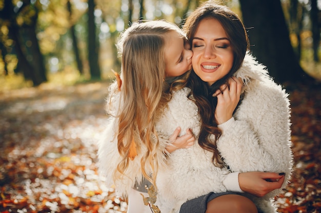 Familia linda y elegante en un parque de otoño