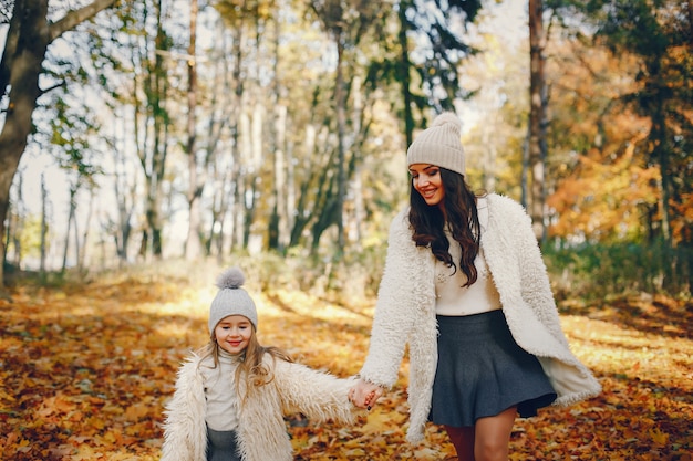 Familia linda y elegante en un parque de otoño