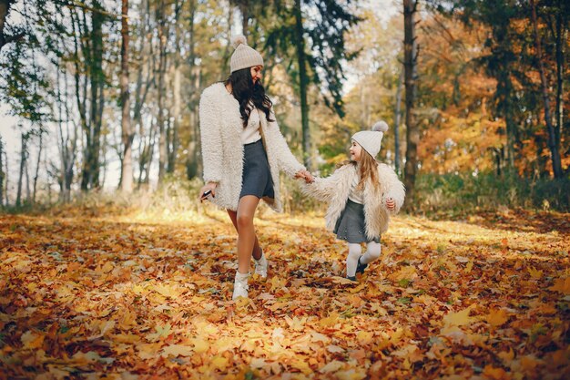 Familia linda y elegante en un parque de otoño