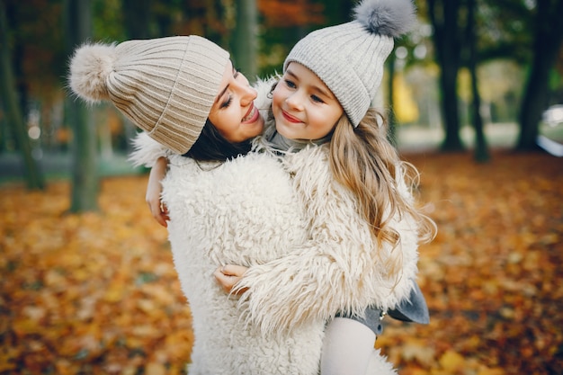 Familia linda y elegante en un parque de otoño