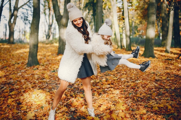 Familia linda y elegante en un parque de otoño