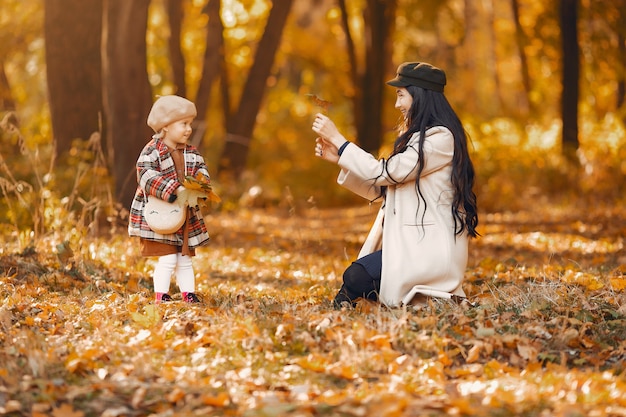 Familia linda y elegante en un parque de otoño